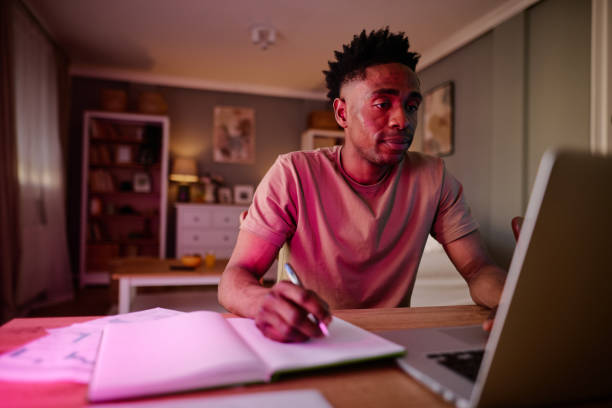istock Focused Man Studying at Home with Laptop and Notebook 2186652524