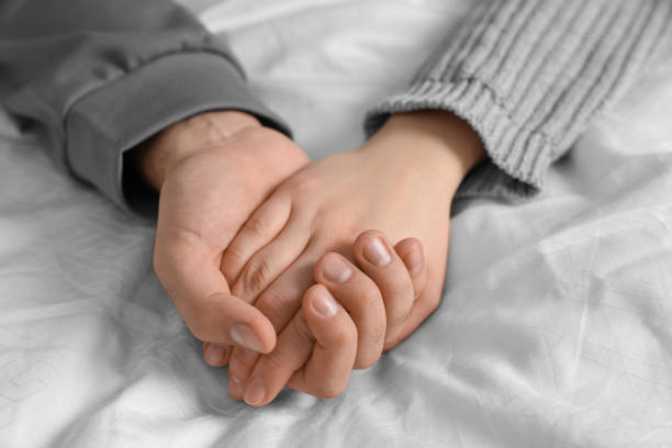 istock Couple holding hands on bed, closeup view 2186656646
