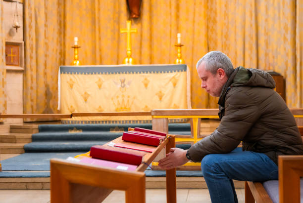 istock Man praying in Anglican church 2186657832