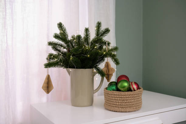 istock Winter pine branches with Christmas decoration in green jug 2186661298