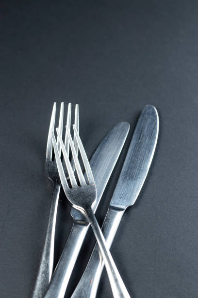 Empty white plate and fork,spoon and table knife on white plate