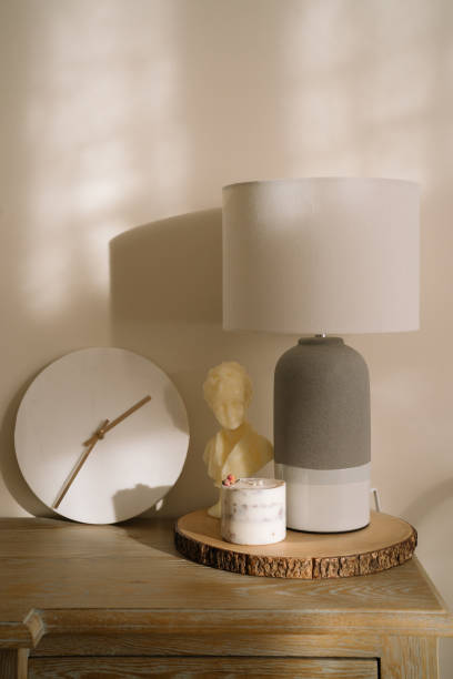 istock minimalist decor for a living room. A minimalistic sideboard with white marble clock, aesthetic candles and a table lamp. Minimal aesthetic and simplicity concept 2186664530