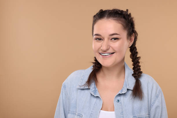 istock Smiling woman with braces on beige background. Space for text 2186665208