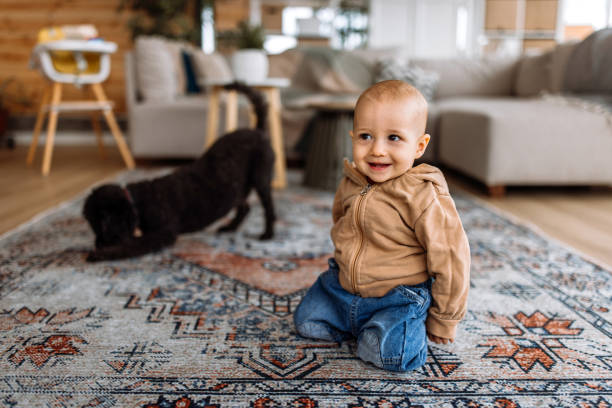 istock Cute baby boy playing with a dog at home 2186666251