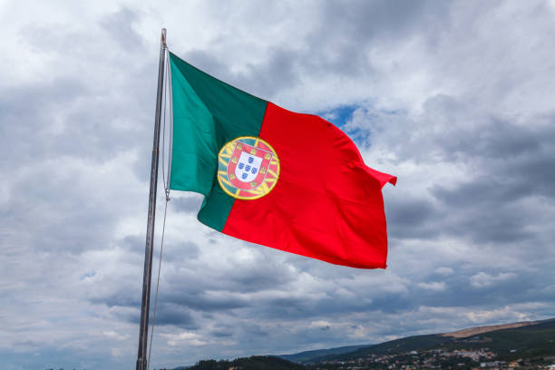 istock A vibrant national flag waving in the wind against a dramatic cloudy sky, symbolizing pride and heritage with a picturesque natural and urban backdrop 2186673167
