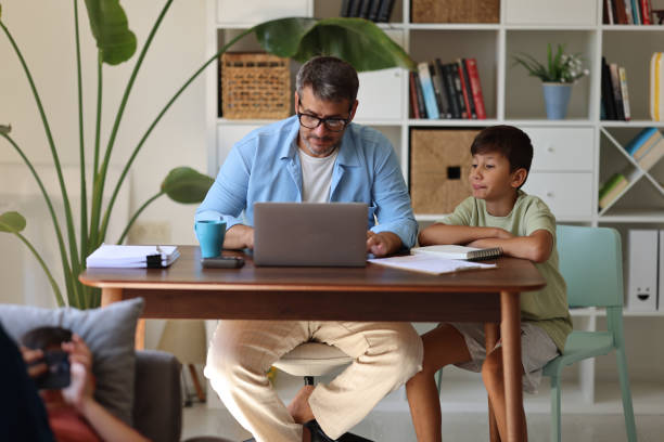 istock Father spending time with his son at desk. Taking break in remote work at home 2186673286