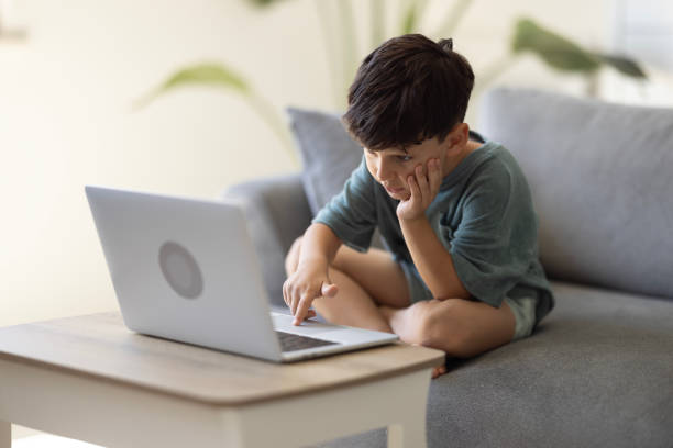 istock Close-up of boy hands typing laptop keyboard. Kid using computer for distance education online. Learning online at home. 2186673813