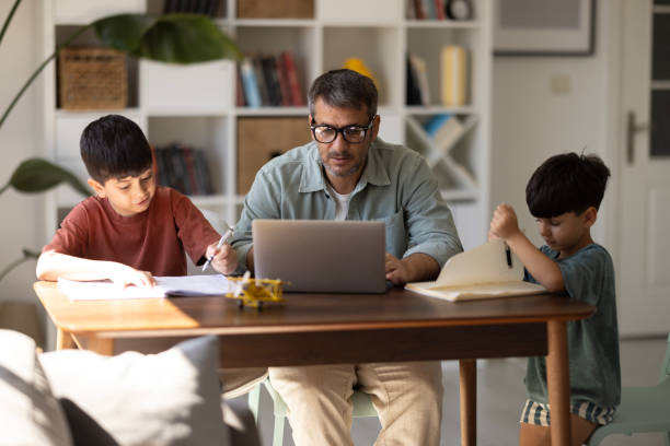istock Father spending time with his son at desk. Taking break in remote work at home 2186673938