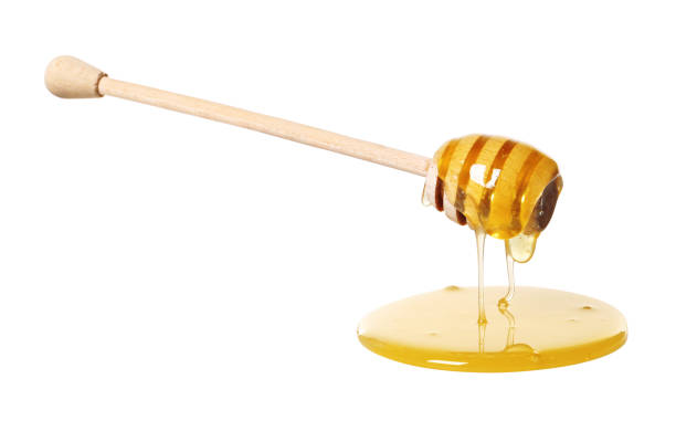 istock Natural honey dripping from dipper on white background 2186678950