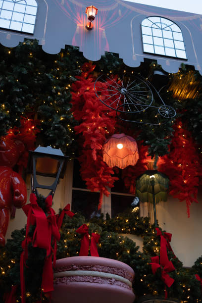 photo Festive holiday display with oversized macaron, vibrant red and green decorations, whimsical lamp shades, and lights creating a magical ambiance for seasonal cheer