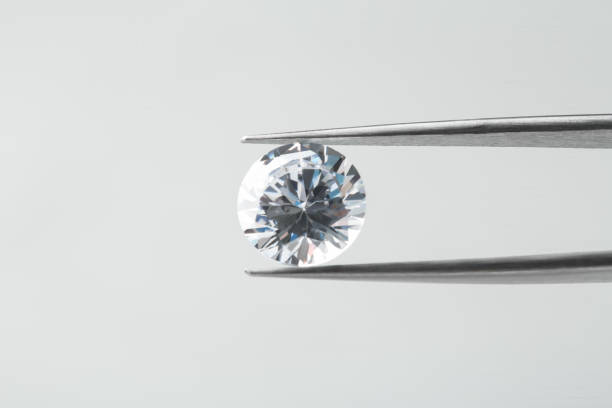 istock Tweezers with beautiful shiny diamond on light gray background, closeup. Space for text 2186682284