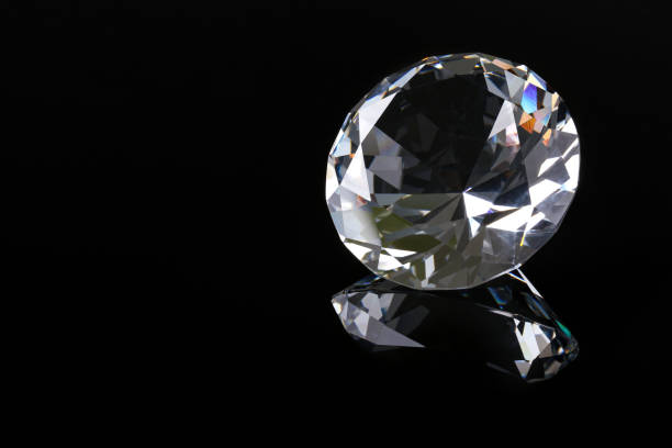 istock Beautiful shiny diamond on black mirror surface, closeup. Space for text 2186682288