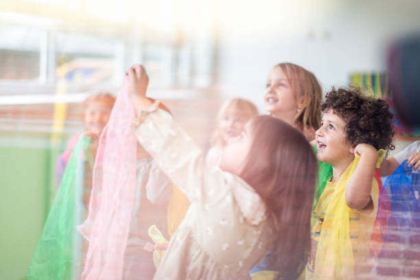 istock happy children in kindergarten, playing with a scarf 2186686432