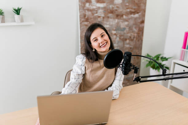 istock Young smiling women recording podcast and doing live streaming using microphone and headphones in recording studio 2186688760