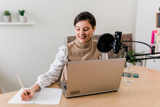 istock Young smiling women recording podcast and doing live streaming using microphone and headphones in recording studio 2186689011