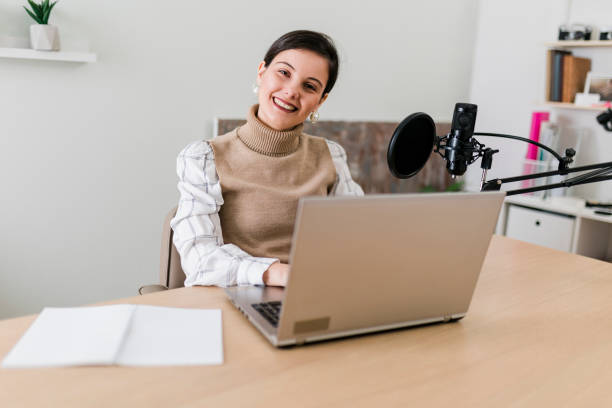 istock Young smiling women recording podcast and doing live streaming using microphone and headphones in recording studio 2186689091