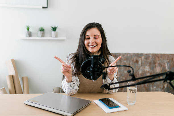 istock Young smiling women recording podcast and doing live streaming using microphone and headphones in recording studio 2186689130