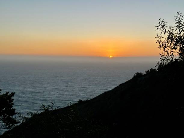istock Sunset Over the Ocean with Silhouetted Hills 2186693923
