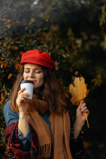 istock modern 40 years old woman in red hat with autumn leafs 2186713968