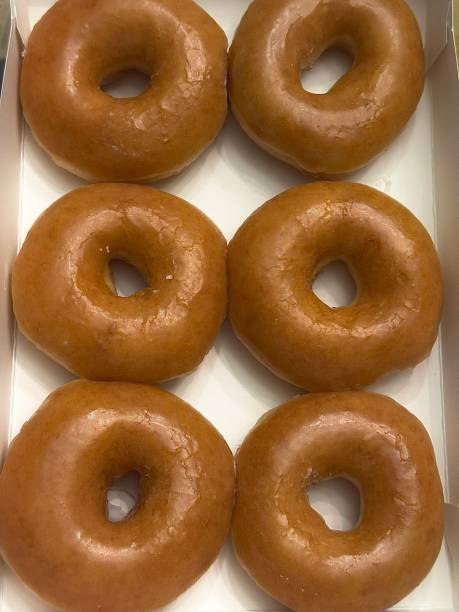 istock A classic glazed donut with a soft, fluffy texture and a sweet, glossy coating. Perfectly balanced between light and sugary, making it an irresistible treat for any time of the day. 2186716139