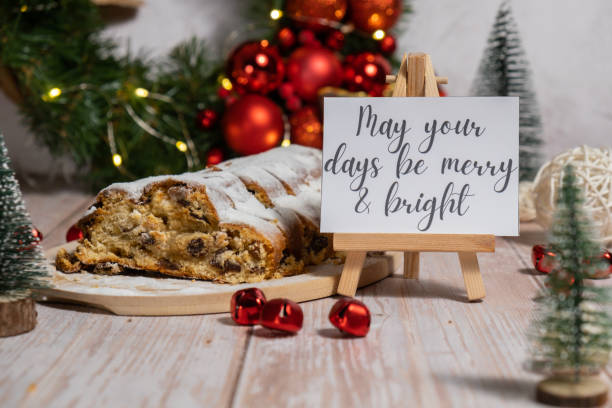 istock Paper note with text MAY YOUR DAYS BE MERRY AND BRIGHT congratulations. Homemade Christmas traditional cake pie with marzipan nuts and dried fruits pastry dessert stollen. Winter holidays season atmosphere. Delicious tasty composition home table setting 2186718706