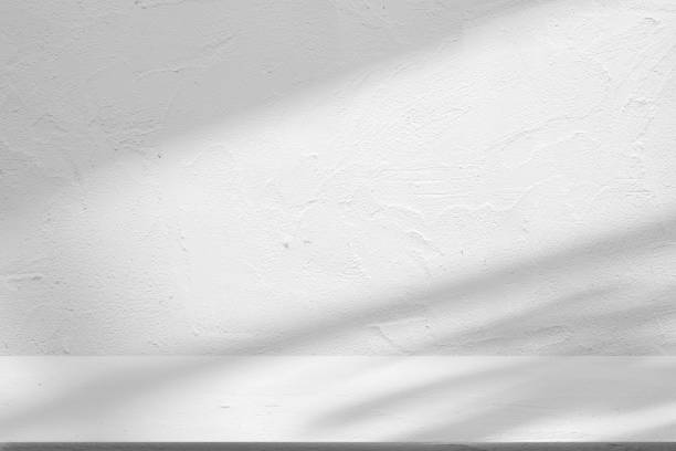 istock Backdrop white podium display with for product. Interior room with sunlight and shadows on white concrete wall surface 2186719767