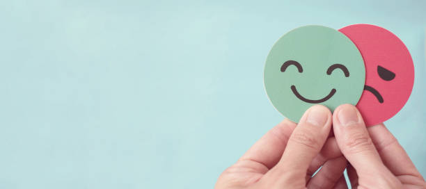 istock Hands holding sad face hiding behind happy face, bipolar and depression, mental health, split personality, mood change concept 2186721629