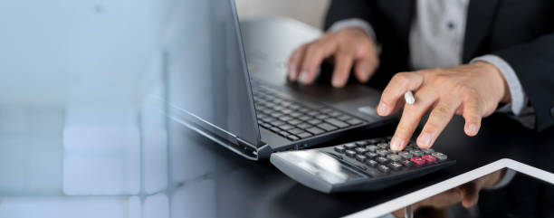 istock Close up Businessman hand using calculator to calculate home finance and writing note 2186723278