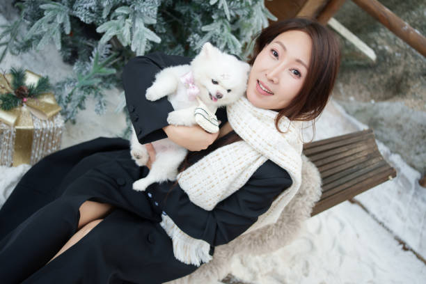 Asian woman holding pet dog