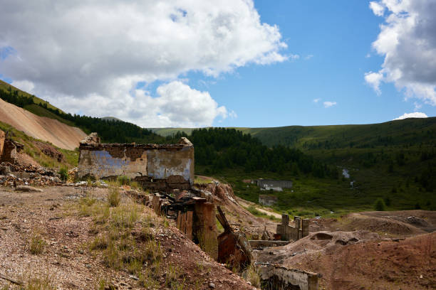 A haunting scene of a house stands in desolation against a rugged mountainous backdrop. The remnants tell a story of destruction and loss, evoking emotions of sorrow and resilience.
