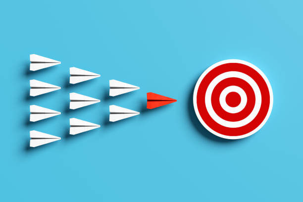 istock Red paper airplane leading white airplanes toward target on blue background 2186729086