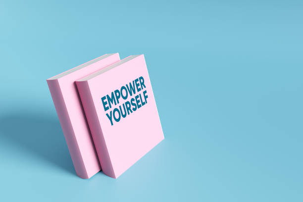 Two pink books with the text empower yourself on a light blue background promoting self-improvement and personal development. 3D render.