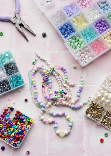 istock Colorful beads and jewelry making tools arranged on pink tile surface 2186730338
