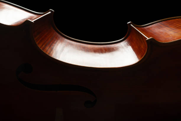 istock cello close up, classical music background, classic string instrument, violin texture wooden backgrounds, dark low key studio photography backlit and black background 2186730804