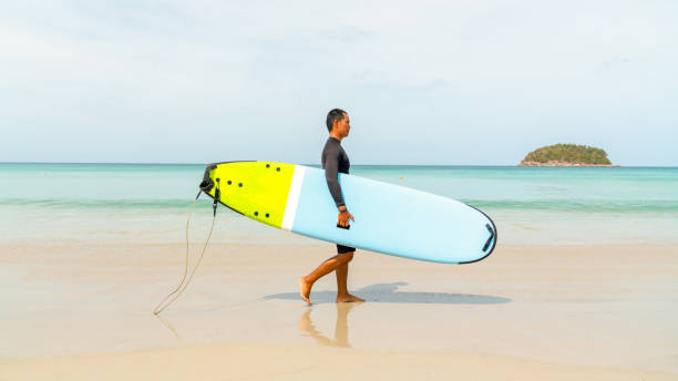 istock Asian man surfing in the sea 2186731035