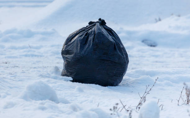 istock A black trash bag is sitting in the snow 2186733559