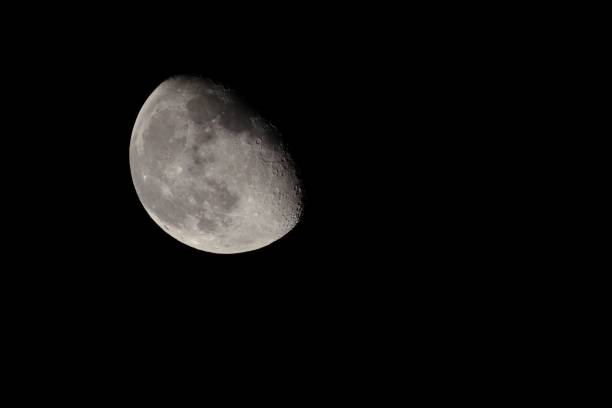 A large side of the moon in a black sky