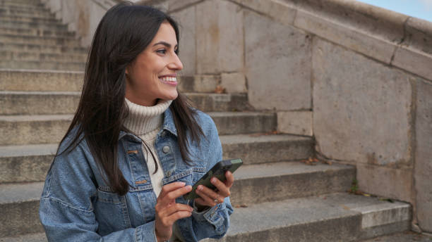 istock A woman sits alone on the steps, holding phone 2186736077