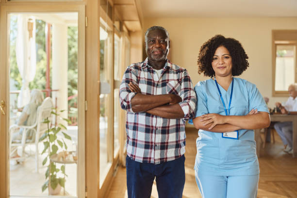 istock Smiling nursing assistant and black senior man in retirement home. 2186738627