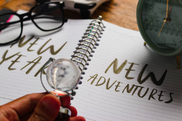 istock Notebook with New Year, New Adventures Surrounded by Travel Essentials 2186739467