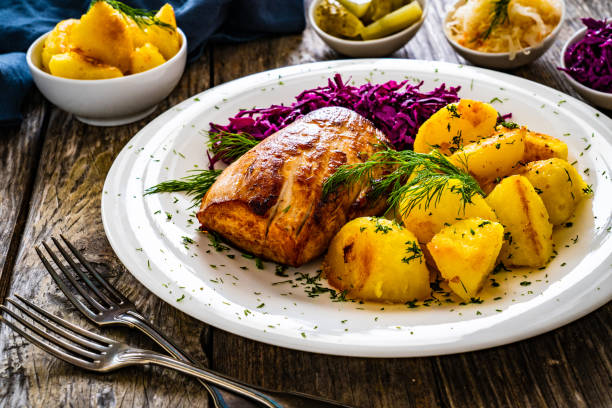 istock Fried pork loin with boiled potatoes and red cabbage on wooden table 2186739655