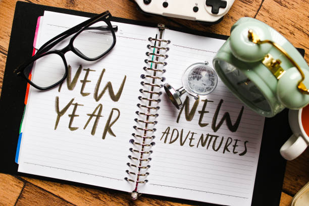 istock Notebook with New Year, New Adventures Surrounded by Travel Essentials 2186740079