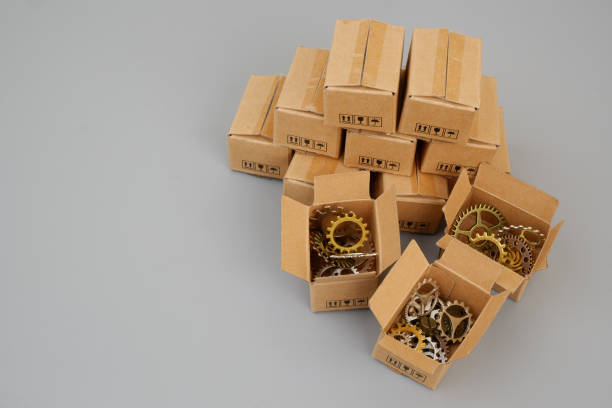 istock Heap of boxes with gear wheels on gray background. 2186741332