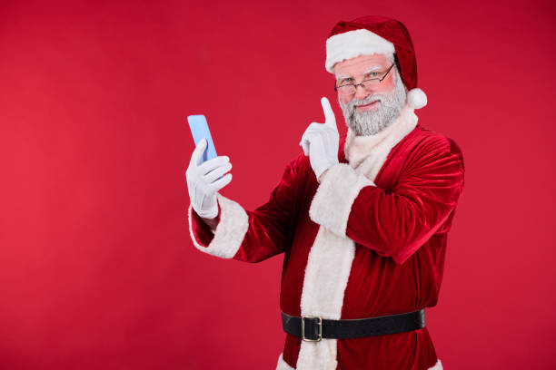 istock Santa Claus Taking Selfie with Smartphone on Red Background 2186745435