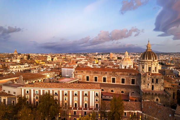Aerial view of the historic centre of Catania with baroque churches against the sky and mount Etna in the background, Sicily, Italy