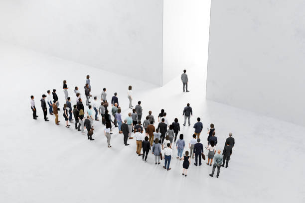 istock People follow their leader approaching bright light in large wall 2186748807