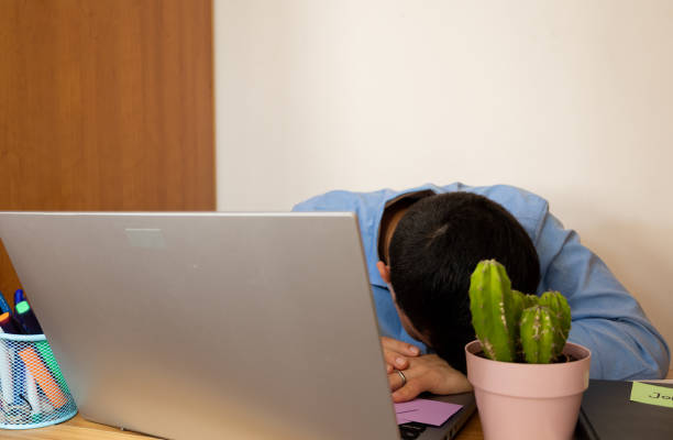 istock Young businessman asleep at his desk due to overwork 2186748990