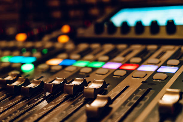 istock Close-up of a mixing console during a recording session at night. A recording studio mixing console with colorful buttons and faders illuminated. 2186749729