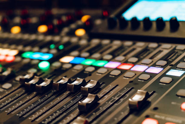 istock Control panel with colorful lights during a live sound mixing session. A detailed view of a sound mixing console with colorful buttons and faders during a live performance. 2186749737