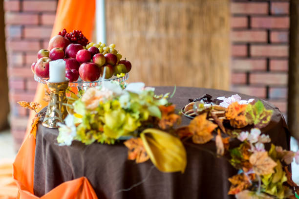 Autumn-themed table arrangement with fruits and floral decorations. A decorative table featuring apples, grapes, and vibrant autumn leaves.